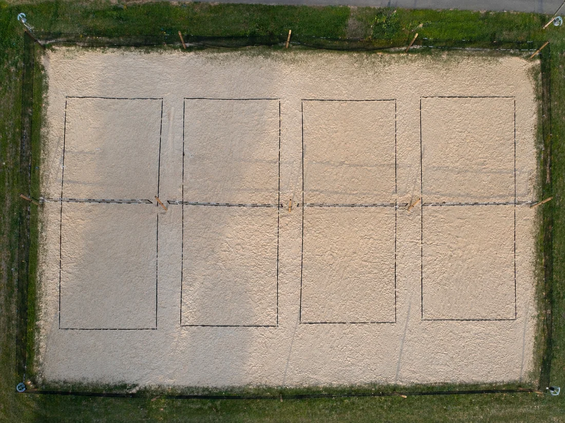 Aerial view of four full-size sand courts on Highway 15 in Franktown.